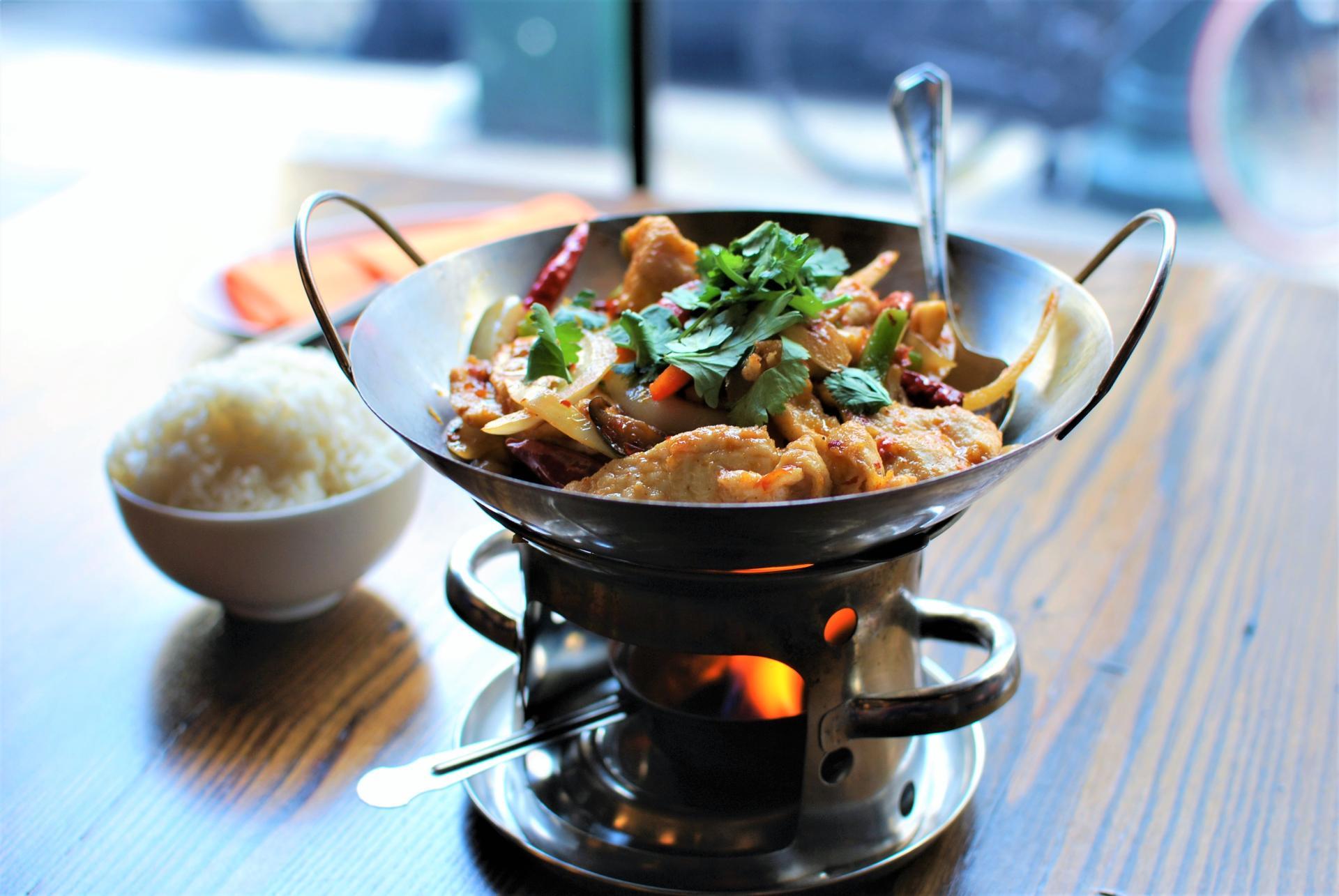 A sizzling hotpot and rice on a table at DanDan, a Sichuan and Taiwanese restaurant at Suburban Square